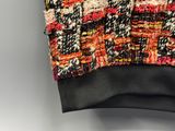 a close up of a sweater hanging on a hanger on a wall