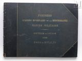 an old black book with gold lettering on it sitting on a white surface