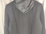 the jacket is hanging on a hanger in front of a curtain