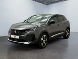 Une voiture grise est garée dans une grande pièce.