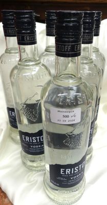 quatre bouteilles de vodka sont alignées sur une nappe blanche