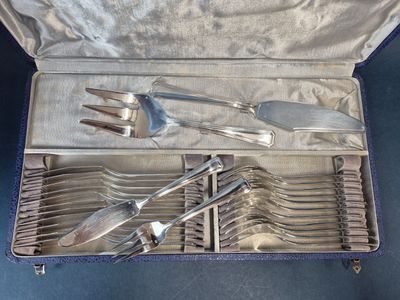 des couverts dans un coffret en argent posé sur un fond bleu