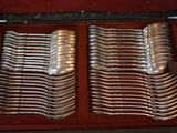 many spoons and forks in a case on the table