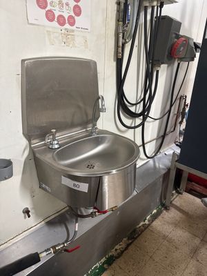 un lavabo en acier inoxydable et une fontaine à eau dans des toilettes publiques