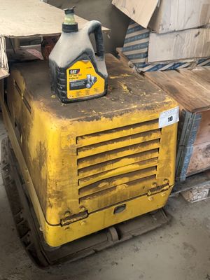 une machine jaune posée sur une palette dans un entrepôt