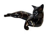 a black and gold cat figurine laying on its back