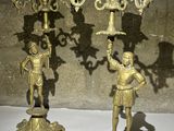 paire de candélabres anciens en laiton ornés de figurines sur des socles