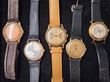 Plusieurs modèles de montres sont exposés dans une vitrine.