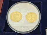 the two gold coins are in a blue box on the table