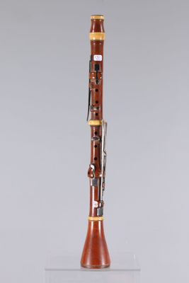 a clarinet on a clear stand with a grey background