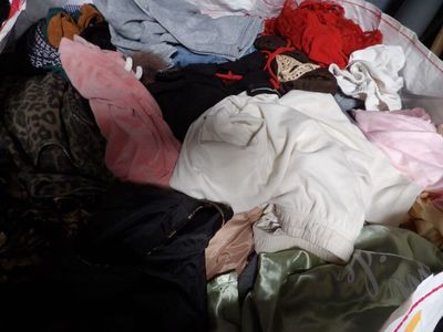 a suitcase full of clothes that is sitting on the floor