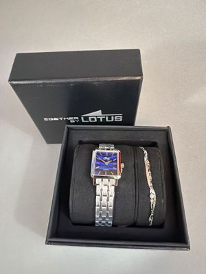 deux montres et un bracelet dans une boîte posée sur une table