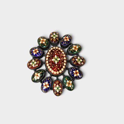 une image représentant une broche multicolore posée sur une surface blanche