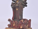 a statue of a woman sitting on top of a red table