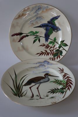 deux assiettes avec des oiseaux peints dessus, posées sur une table