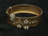 a close up of a gold ring with pearls on it