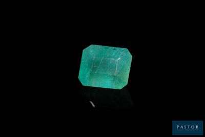 a green emerald stone on a black surface