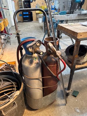 de nombreuses bouteilles de gaz et un chariot dans un garage