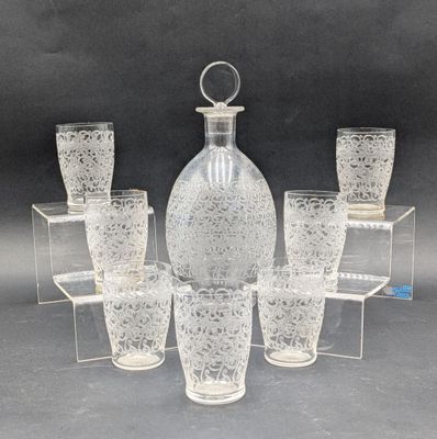 six verres et une carafe posés sur une table