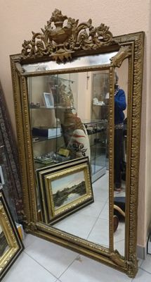 a mirror that is sitting on the floor next to some pictures