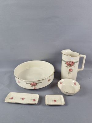 un gros plan sur une table dressée avec un pichet, un saladier, une assiette et des tasses
