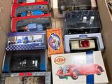 une boîte remplie de petites voitures et de télécommandes posée par terre