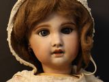 a close up of a doll with a hat on