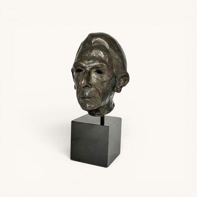 sculpture of a man ' s head on a black stand