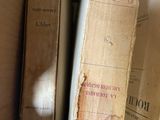 several old books are stacked on top of each other in a box