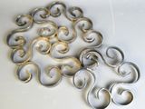 un tas d'anneaux métalliques posés sur une surface blanche
