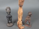 trois figurines en bois de formes et de tailles différentes posées sur une surface grise