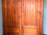 an image of a bedroom with a wooden armoire and a bed