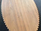 a round wooden table on a black floor