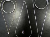 trois types différents de colliers et de bagues sur un fond noir