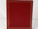 a red book with gold trimming on the cover