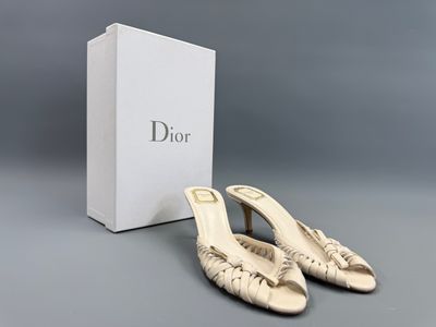 une paire de chaussures blanches avec une boîte posée sur une surface grise