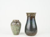two vases sitting next to each other on a white surface