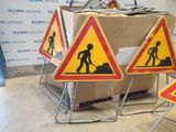 three road signs that are on a stand in front of a box