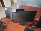 two monitors sitting on a desk next to a laptop