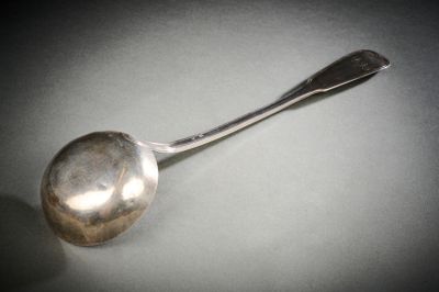 une cuillère en argent avec un manche de cuillère sur une table