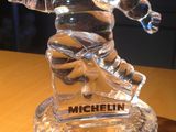 une figurine en verre représentant un homme, posée sur une table