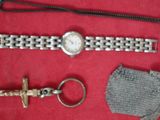 une montre, un porte-clés et un anneau à clés posés sur un tissu rouge