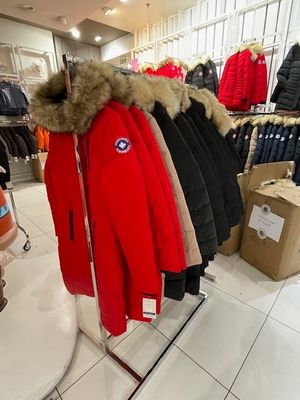 beaucoup de manteaux suspendus à un portant dans un magasin