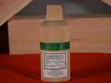 a small bottle of liquid sitting on a red cloth