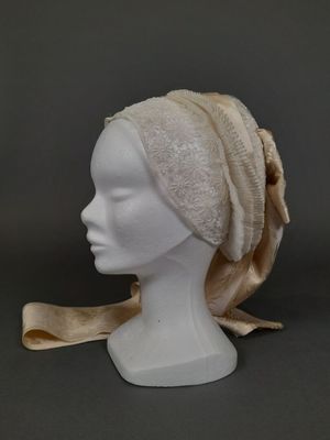 une tête de mannequin blanche surmontée d'un foulard