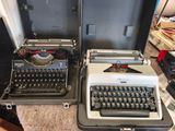 two old typewriters sitting next to each other on a table