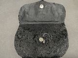 a black purse with a beaded flower on the front