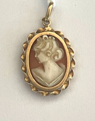 un pendentif plaqué or représente le profil d'une femme
