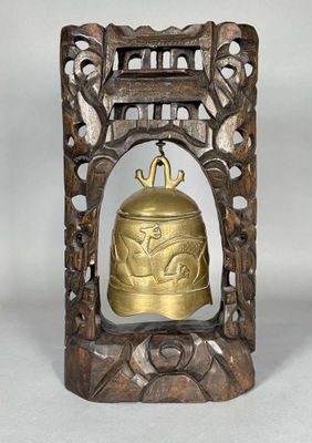 an old brass bell in a wooden frame on a white background