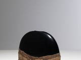 a black and white sculpture on a white surface with a gray background